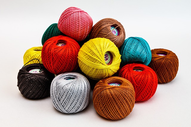 quilting supplies with thread spools, needles, and batting on a craft table
